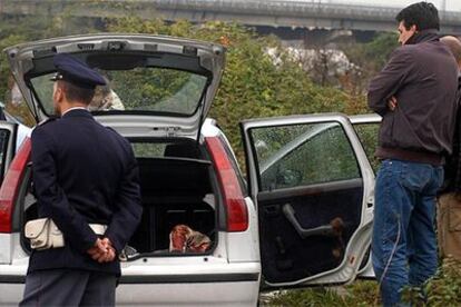 Unos <i>carabinieri</i> inspeccionan el cuerpo de un hombre hallado el martes pasado en un coche cerca de Nápoles.