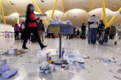 Basura acumulada en el suelo y las papeleras de la T4 con motivo de una huelga de la contrata de la limpieza. EFE/Archivo