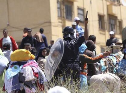 Un policía local desaloja a los vecinos de la zona donde ocurrieron los hechos.