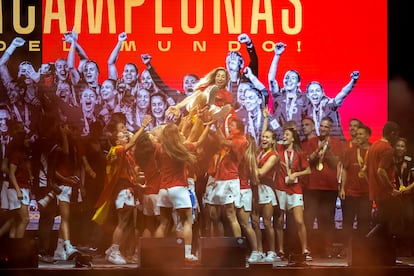 Las jugadoras mantean a Olga Carmona, durante la celebración de este lunes con la afición, en Madrid.
