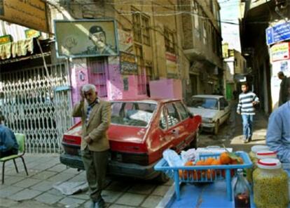 El retrato de Sadam Husein, sobre una esquina, preside una escena cotidiana en una calle de Bagdad el pasado viernes.