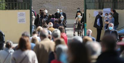 Decenas de personas hacen cola para votar en el Colegio Joaquín Turina de Arturo Soria, este martes.