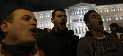 Tres hombres gritan unos eslogans durante la marcha silenciosa en solidaridad con el Gobierno griego frente al Parlamento de Atenas, este jueves.