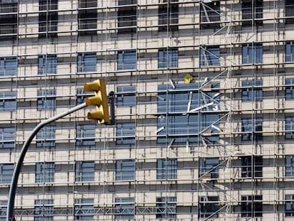 El reloj del hotel Plaza, de la plaza de Espanya, parapetado por la trama de andamios.