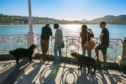 Varias personas junto a la barandilla 'belle époque' del paseo de La Concha, en San Sebastián, obra del que fue arquitecto municipal Juan Rafael Alday.