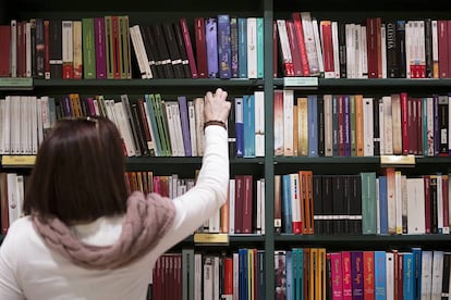 Una mujer coge un libro en una librer&iacute;a de Sevilla. 