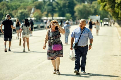 Una mujer y un hombre caminan por el Parque de El Retiro de Madrid, este lunes durante la ola de calor.