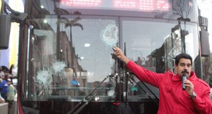 Maduro pointing to buses vandalized during the protests.