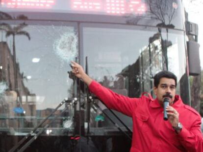 Maduro pointing to buses vandalized during the protests.