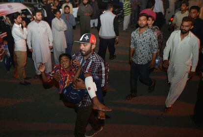 Un paquistaní traslada a un niño herido al hospital de Lahore.