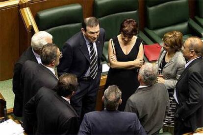 Ibarretxe (de frente) charla con varios miembros de su anterior Gabinete durante el pleno de investidura de junio.