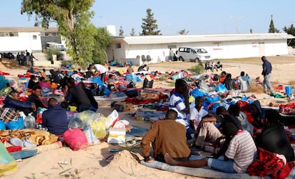 Los migrantes con sus pertenencias, afuera del centro de detención bombardeado en Trípoli.