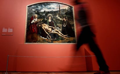 Una mujer pasa ante la obra 'Piedad desplá', de Bartolomé Bermejo en el muestra que el Museo del Prado le dedica al artista.