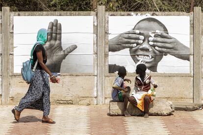 Los transeuntes observan las fotos de la exposición Je suis lá en Dakar, Senegal.