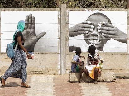 Los transeuntes observan las fotos de la exposición Je suis lá en Dakar, Senegal.