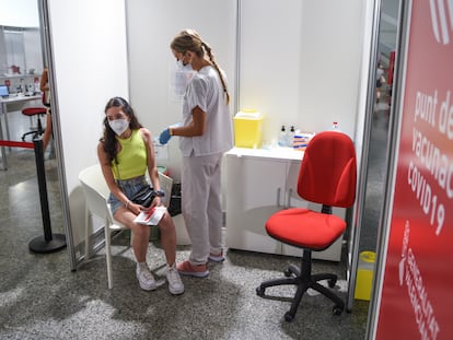 Una sanitaria vacuna a una adolescente con la primera dosis de Moderna, este lunes en la Ciudad de las Artes de Valencia.