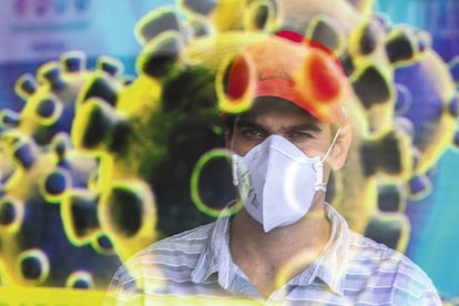 Un hombre con máscara se refleja en un anuncio sobre el coronavirus, en Brasilia (Brasil)