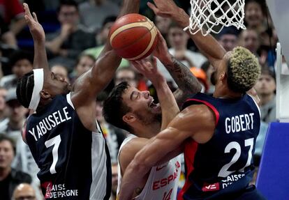 Willy Hernángomez intenta hacer canasta entre los jugadores Guerschon Yabusele (izquierda) y Rudy Gobert (derecha).