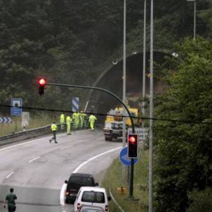 Operarios retiran una barricada del interior de uno de los túneles del Padrún en donde un grupo de mineros cortó el tráfico a las 6,30 de la mañana con barricadas de neumáticos ardiendo en las dos entradas de estos túneles de la A-66 en las próximidades de Oviedo.