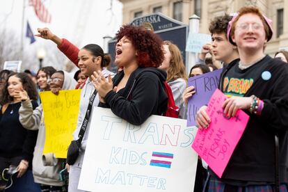 Mae Keller, a senior, carries a "Trans Kids Matter" sign and cheers as hundreds of students walk out of school on Transgender Day of Visibility outside Omaha Central High School on March 31, 2023, in Omaha, Neb.