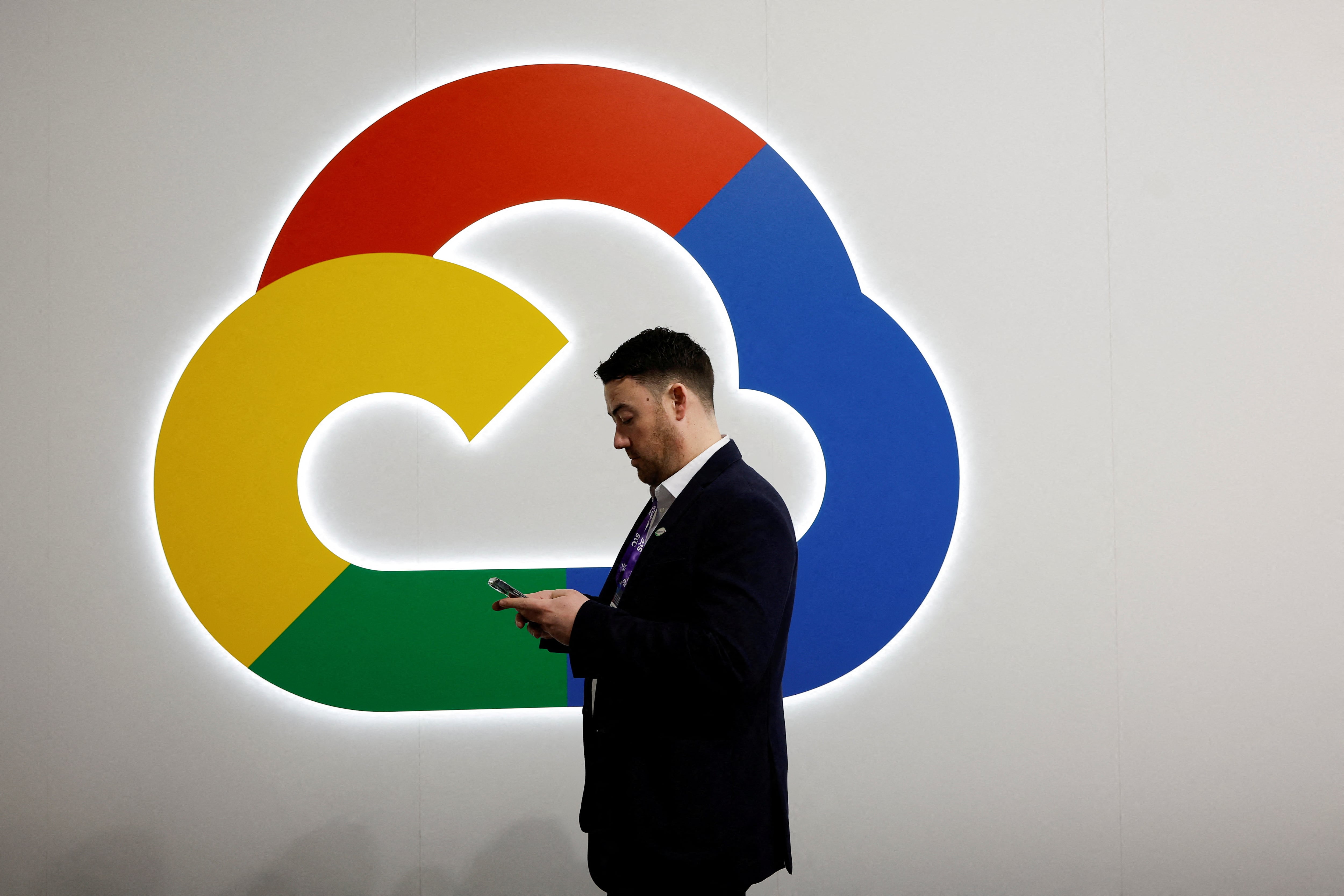 Una persona mira su teléfono delante del logo de Google Cloud, en el Mobile World Congress (MWC) en Barcelona, el 27 de febrero de 2024.