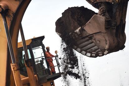 Os bombeiros usam máquinas pesadas na busca por vítimas.