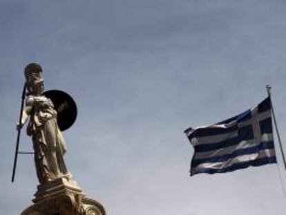 Una bandera griega ondea al lado de la estatua de la diosa 'Palas Atenea' en el centro de Atenas, Grecia. EFE/Archivo