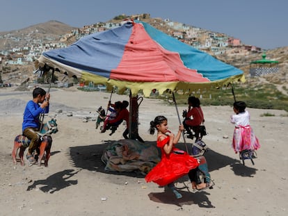 Niños afganos juegan en un carrusel durante el festival musulmán de Eid al-Adha,  en Kabul, Afganistán, el 31 de julio de 2020.