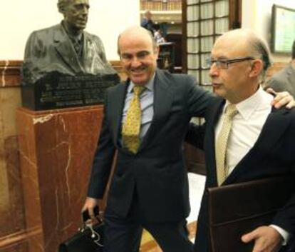 El ministro de Economía, Luis de Guindos (i) y el titular de Hacienda, Cristóbal Montoro, durante el pleno del Congreso que debate las enmiendas a la totalidad presentadas al proyecto de Ley de Presupuestos Generales del Estado para 2014.