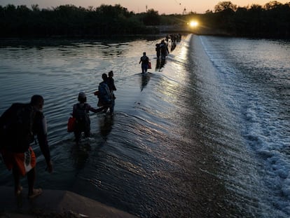 Un grupo de migrantes haitianos cruzan el Río Bravo para obtener alimentos y suministros cerca del puerto de entrada Del Río-Acuña en Ciudad Acuña, estado de Coahuila, México.