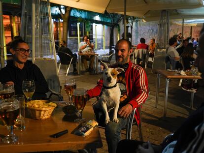 Carolina y Asier junto al pero Lupo y unos amigos en la terraza del restaurante Conache, en la plaza de San Ildefonso de Malasaña