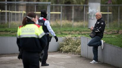 Agentes de los Mossos d Esquadra piden a un hombre que toma el aire en el Parque de Joan Miro que vuelva a su casa. 