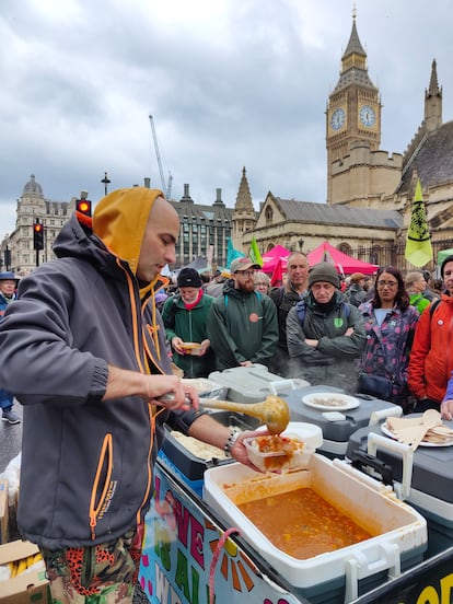 Un activista de Extinction Rebellion da de comer a los ciudadanos este viernes, frente al Parlamento del Reino Unido