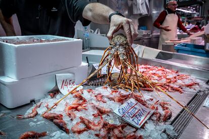 Un empleado muestra productos en una pescadería de un mercado de Valencia.