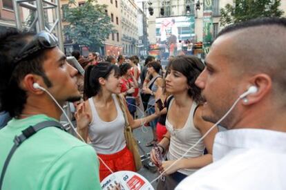 Algunos jóvenes asisten en la plaza de Chueca a la sesión musical silenciosa de ayer.