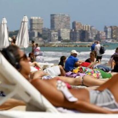 Turistas disfrutan del sol y las altas temperaturas en la playa del Postiguet de Alicante.