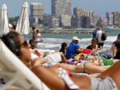 Turistas disfrutan del sol y las altas temperaturas en la playa del Postiguet de Alicante.