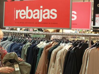 Una se&ntilde;ora busca prendas de ropa en rebajas.