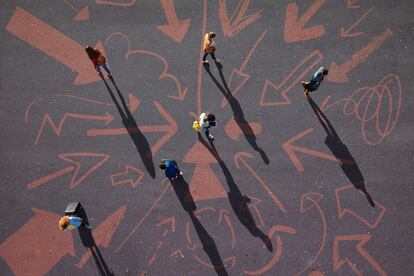 Group of young adults, photographed from above, on various painted tarmac surface, at sunrise.