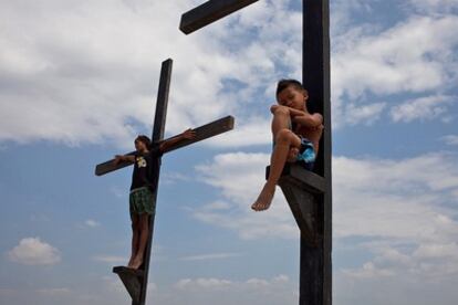 Dos niños juegan en las cruces que serán utilizadas para crucificar a algunos hombres durante el ritual que se repite cada año en Semana Santa en San Fernando, Pampanga (Filipinas).