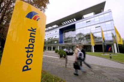 Dos peatones caminan cerca de la sede del banco alemán Deutsche Postbank en Bonn, Alemania.