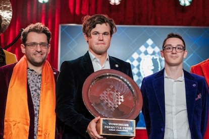 Carlsen con el trofeo de vencedor junto a Caruana (2º, derecha) y Aronián (3º), este viernes en Weissenhaus (Alemania)