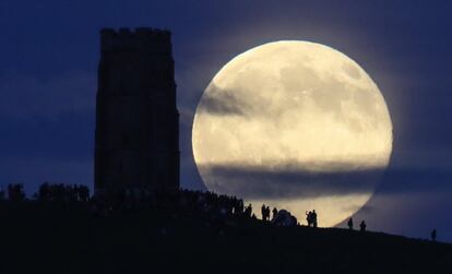 La luna llena se eleva detrás de la Torre Glastonbury, que celebra el solsticio de verano en Somerset, el 20 de junio de 2016.