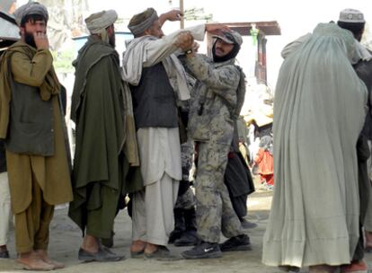 Un guardia de la frontera afgana cachea a un hombre procedente de Pakistán en Spin Boldak, Afganistán.