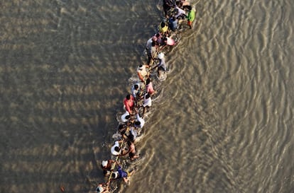 Trabajadores indios tiran de una boya de pontones con una cuerda en el río Ganges para la construcción de un puente flotante de cara al próximo festival Kumbh Mela, en Allahabad.