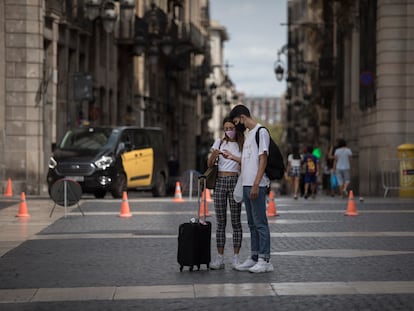 Dos turistas revisan su móvil en Barcelona.