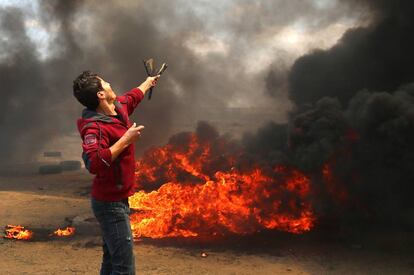 Un palestino lanza piedras durante la protesta en la frontera entre Gaza e Israel, el 14 de mayo de 2018.