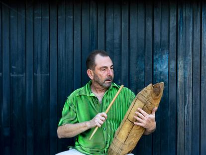 Villalba, en la puerta de su garaje en Chiva (Valencia), tocando el teponaztli mexicano sentado en un cajón flamenco.