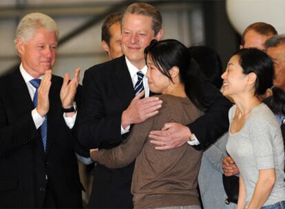 Bill Clinton y Al Gore, con las periodistas Laura Ling (abrazada por el ex vicepresidente) y Euna Lee, en el aeropuerto de Burbank (EE UU).