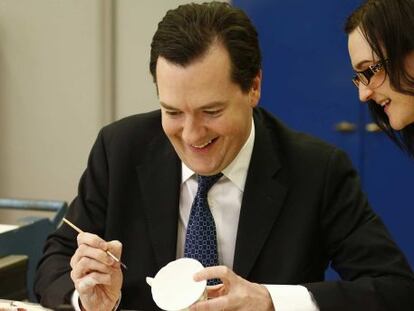 George Osborne decora una taza en su visita a Derby este jueves.